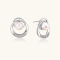 White gold-plated brass earrings with circular design, freshwater pearl center, and diamond accents