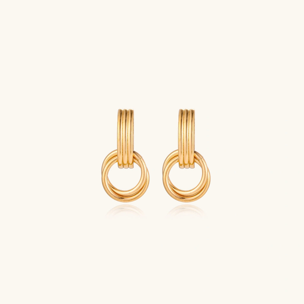 Gold stud earrings with vertical ridged bar connecting to triple interlocking circular rings on white background