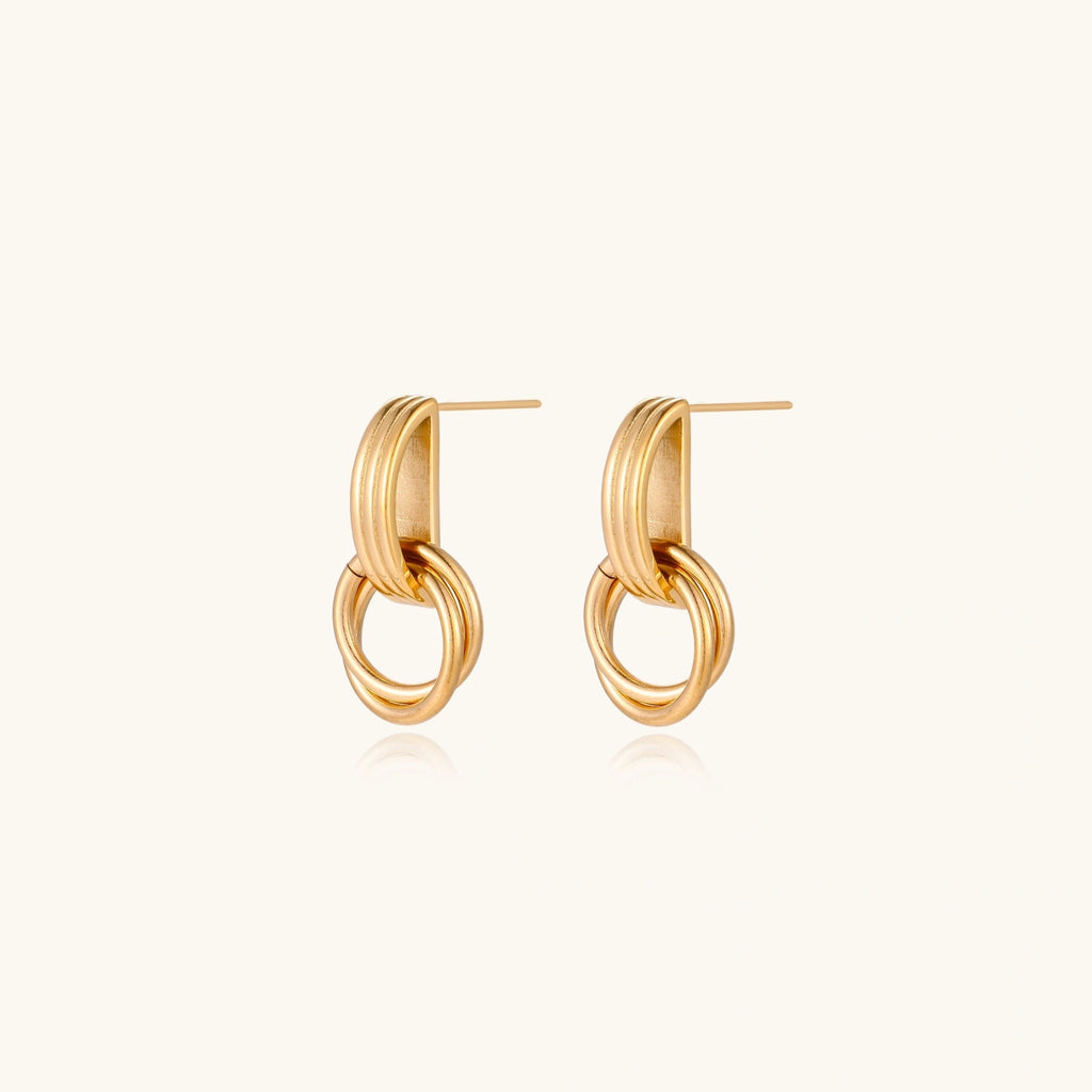 Gold stud earrings with vertical ridged bar connecting to triple interlocking circular rings on white background