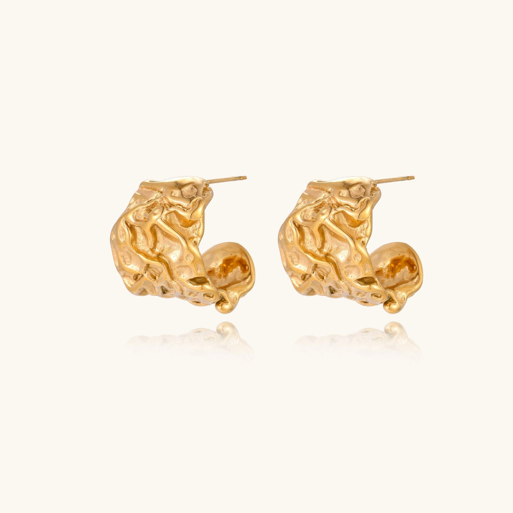 Chunky gold-plated hoop earrings with organic crumpled texture on cream background, 21.5mm sculptural design